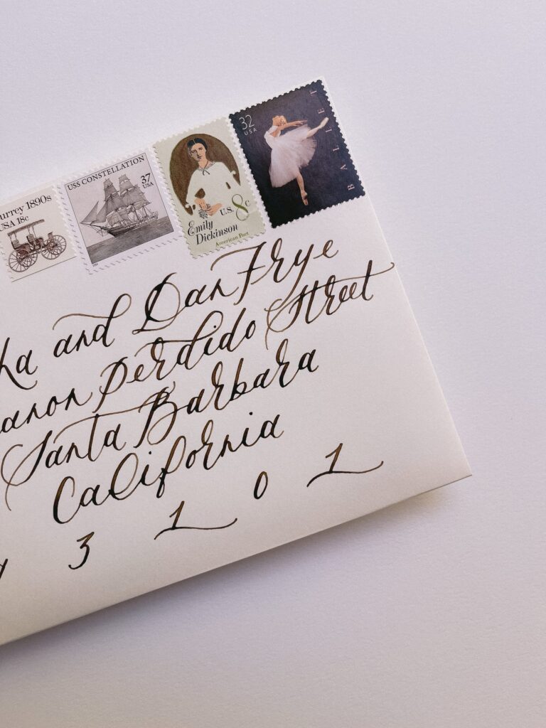 Wedding invitation envelope featuring modern calligraphy and vintage stamps